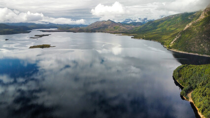 Dark lakes between the mountains of Tasmania on a cloudy day, seen from above