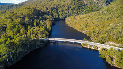 Dark lakes between the mountains of Tasmania on a sunny day, seen from above