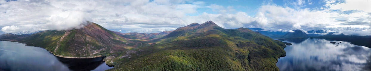 Fototapeta premium Dark lakes between the mountains of Tasmania on a cloudy day, seen from above