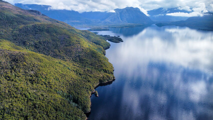 Dark lakes between the mountains of Tasmania on a cloudy day, seen from above