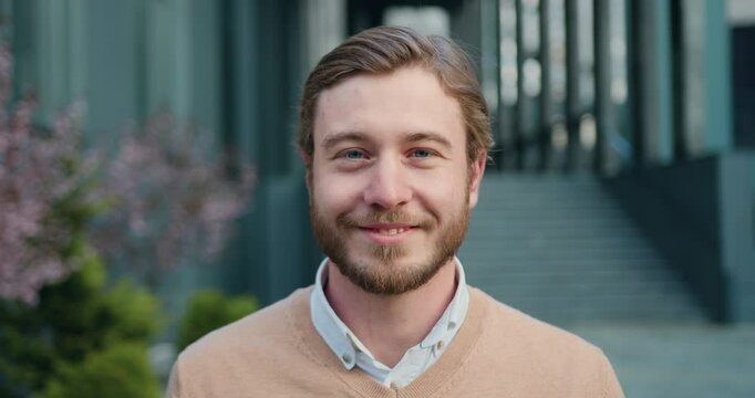 Close-up portrait of man standing outdoors take off glasses alone smiling looking at camera. Concept of people and lifestyle.