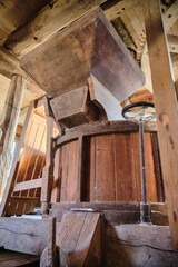 Millstone and wooden gear mechanism inside historic mill