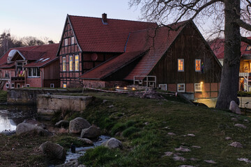 Fototapeta premium Bruchmühle in Bruchhausen-Vilsen, with half-timbered house, mill dike and tree at dawn