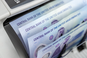 UAE money, Counting machine Emirates banknotes of 50 dirhams. Financial concept. Converting...