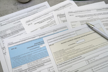 Obraz premium PIT-36 PIT-37 PIT-38 Annual tax return polish pit forms with pen on table