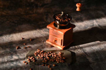 coffee beans scattered on the table. manual coffee grinder