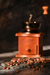 coffee beans scattered on the table. manual coffee grinder
