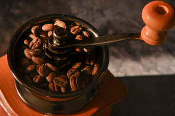 coffee beans scattered on the table. manual coffee grinder