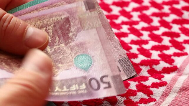 Jordan money. Man counting Jordanian dinars. Financial business concept. 50 and 20 dinar banknotes
