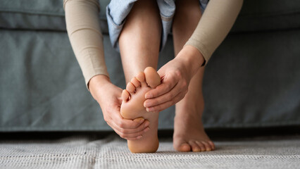 Young woman feeling pain in her foot