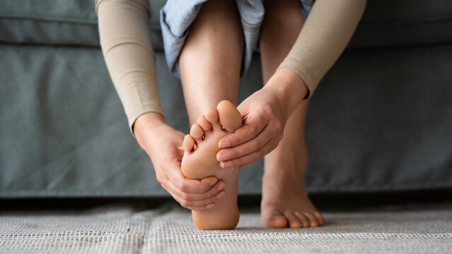 Young woman feeling pain in her foot