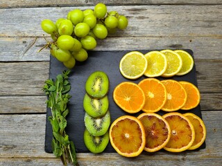 Top view of various citrus fruits arranged on a granite cutting board