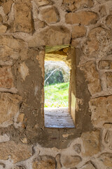 A small window in the remains of a building with several arches near the ruins of the Ancient Sinagogue in Bar'am National Park in northern Israel near the Lebanese border.
