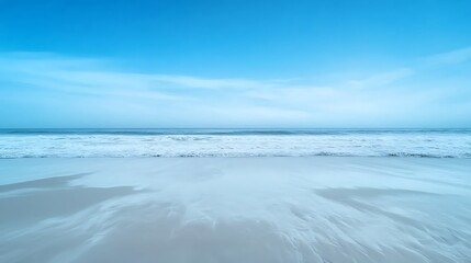 Tranquil Ocean Shoreline with Gentle Waves Under a Bright Blue Sky and Soft Sandy Beach