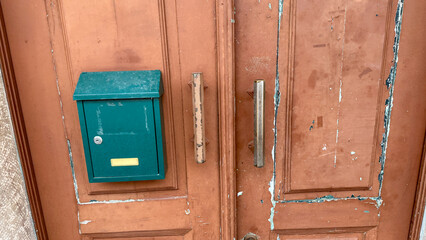 Worn wooden door with vintage mailbox, urban nostalgia, rustic architecture, timeless entryway charm