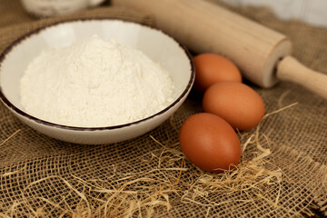 Baking products - flour, eggs. Flour and eggs on the table close-up