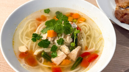 Warm chicken noodle soup with vegetables, comforting homemade meal, winter warmth, nourishing cuisine