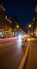 Fototapeta premium Nighttime urban street scene with light trails and construction in a city setting