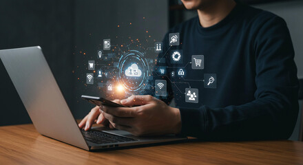 Person using laptop and smartphone with cloud computing and digital technology interface