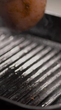 Barbecued chicken breasts on a grill pan with fresh green vegetable and chery tomatoes and rosemary twigs.