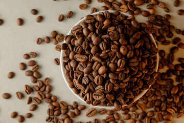 Freshly roasted coffee beans spilling onto a rustic table surface
