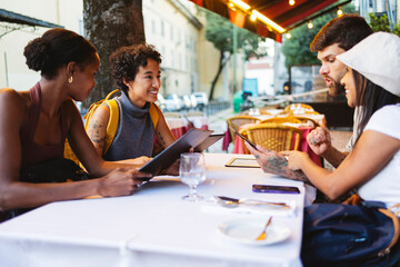 Tourists ordering food using digital menu at restaurant