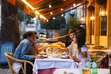 Friends enjoying dinner together at outdoor restaurant