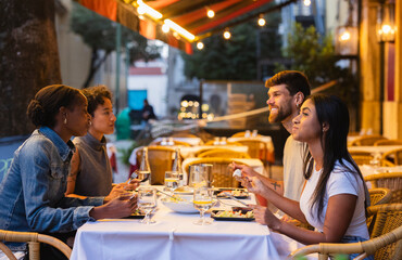 Friends enjoying dinner together at outdoor restaurant