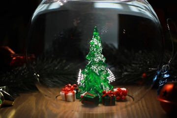 Glowing Christmas Tree in Glass Bauble with Gifts and Ornaments