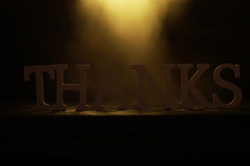 Backlit 'Thanks' Typography with Dramatic Lighting in Dark Background