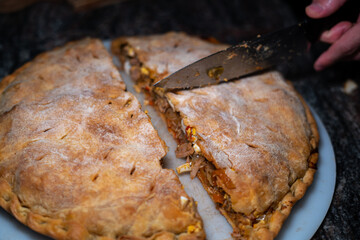 Hand slicing fishpie topview