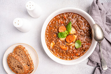 Traditional Spanish dish of lentil stew with chorizo and potatoes on a white background. Top view composition. . High quality photo