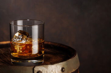 A classic whiskey glass filled with golden amber whiskey