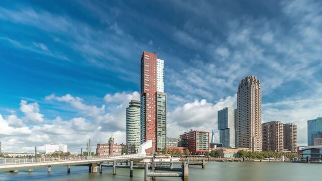 Hyperlapse of the Rijnhaven Bridge, known locally as Hoerenloper, in Rotterdam, Netherlands. A pedestrian and bicycle bridge with modern skyscrapers and cloudy skies in the background timelapse