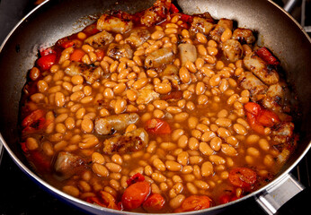 Steak and beans, a plate of baked beans with chunks of beef steak isolated on white