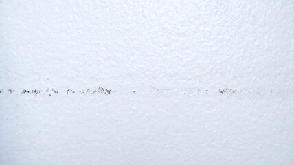 Wall texture background has scraped line caused by furniture stuck on the wall for long time. White cement texture for dirty, aged, old, repair, interior, and house concepts. Close-up concrete wall.