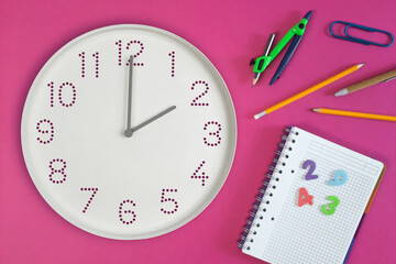Study time. Time on white wall clock 1 o'clock and school notebook, numbers, pen, pencil, paper...