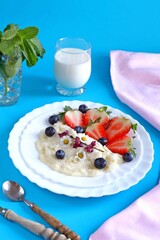Healthy Breakfast with Oatmeal Berries and Milk on a Colorful Background