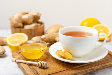 Cup of hot ginger tea with slices of ginger root on wooden background. Warming drink. Alternative medicine. Tea with honey, lemon, ginger and mint. Space for text. Copy space