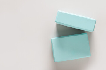 Green yoga blocks on gray background. Yoga practice, relaxation and meditation concept. Top view with copy space.