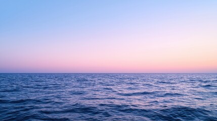 Obraz premium Serene ocean view at twilight, showcasing gentle waves under a gradient sky transitioning from blue to pink.