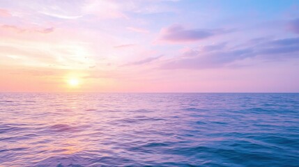 Obraz premium A serene seascape featuring calm waters and a vibrant sunset with pastel hues reflecting on the ocean's surface.