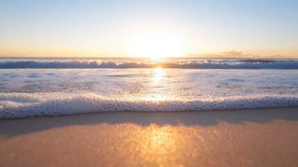 Obraz premium A serene beach scene at sunset, with gentle waves lapping against a sandy shore, illuminated by the warm light of the setting sun.