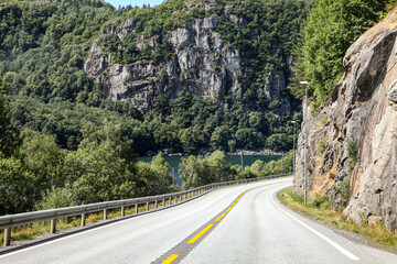 A road with a yellow line and a sign on the side in Norway