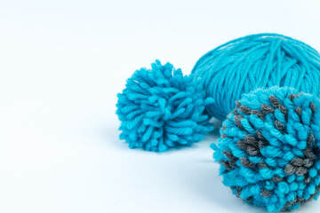 Skein of blue threads for knitting on a white background. pompon. fluffy soft pompon made of yarn.