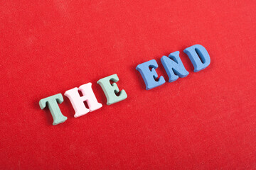 THE END word on red background composed from colorful abc alphabet block wooden letters, copy space for ad text. Learning english concept.