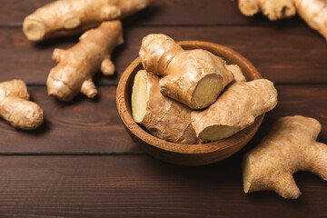Fresh ginger on wooden background. Dry ginger. Sliced ​​ginger with honey and lemon. Ginger...