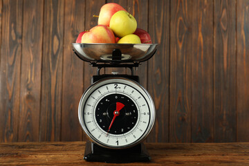 Retro mechanical kitchen scale with apples on wooden table