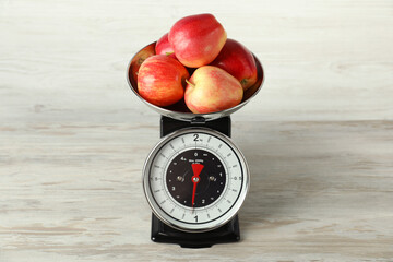 Retro mechanical kitchen scale with apples on wooden table