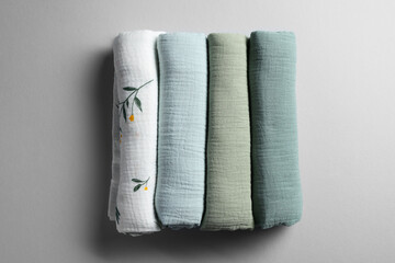 Rolled baby blankets on light grey background, flat lay